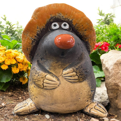 Keramikfigur Maulwurf mit großem Hut, Garten-Deko zwischen Blumen und Steinen platziert