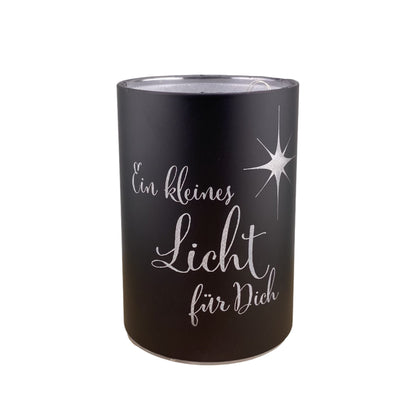 Eine schwarze LED Dekolicht Säule mit Spruch "Ein kleines Licht für Dich!" und kleinem Stern ist 10 cm groß und vor weißem Hintergrund platziert.