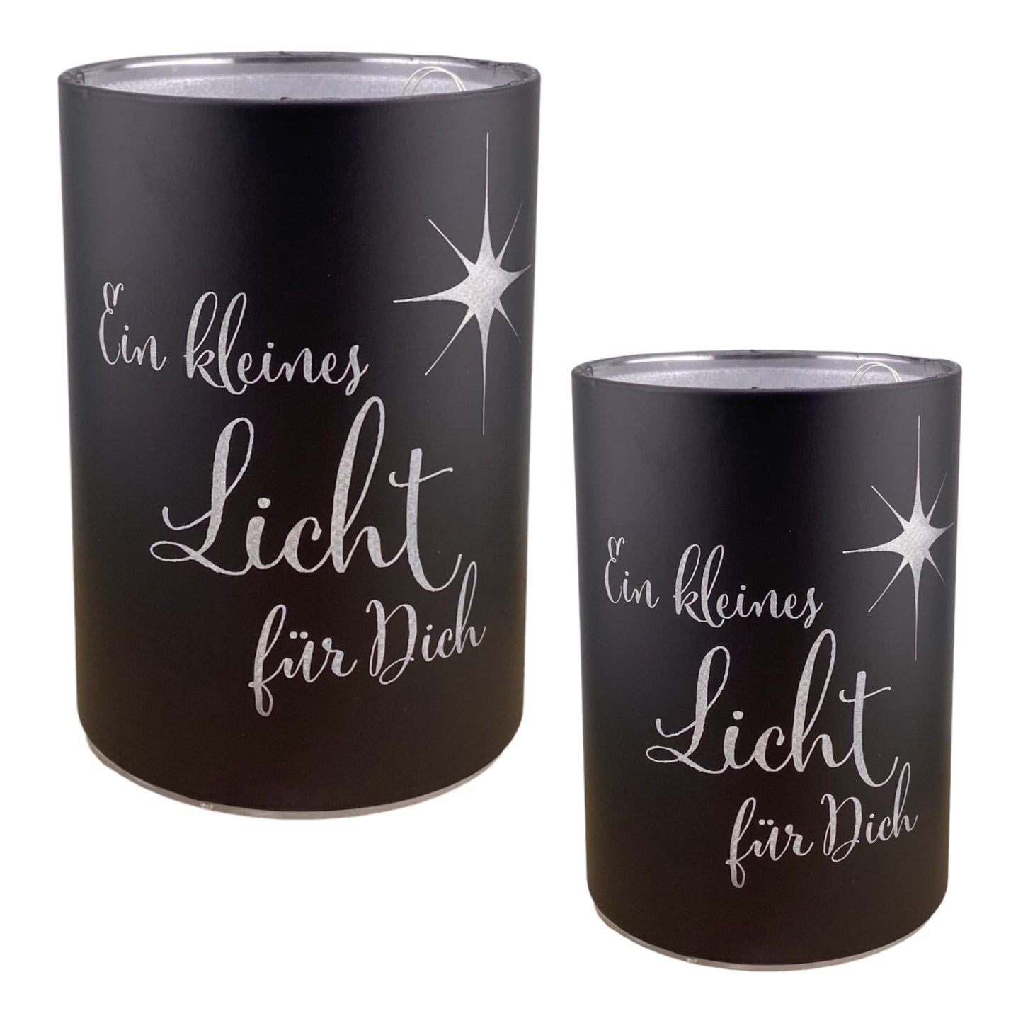 Zwei schwarze LED Dekolicht Säulen mit Spruch "Ein kleines Licht für Dich!" und kleinem Stern sind unterschiedlich groß und vor weißem Hintergrund platziert. 