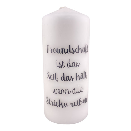 Eine große, weiße Kerze mit schwarzem Schriftzug "Freundschaft ist das Seil, das hält, wenn alle Stricke reißen". Die Dekokerze ist 18,5cm groß und vor weißem Hintergrund platziert.