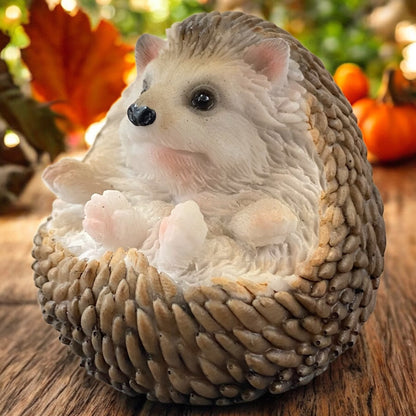 Liegende Igel-Figur mit naturgetreuer Optik, detailreiche Herbstdekoration auf Moos im Wald.