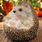 Liegende Igel-Figur mit naturgetreuer Optik, detailreiche Herbstdekoration auf Moos im Wald.