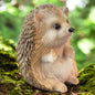 Sitzende Igel-Figur mit feinen Details, naturgetreue Herbstdekoration auf Moos mit Waldhintergrund.