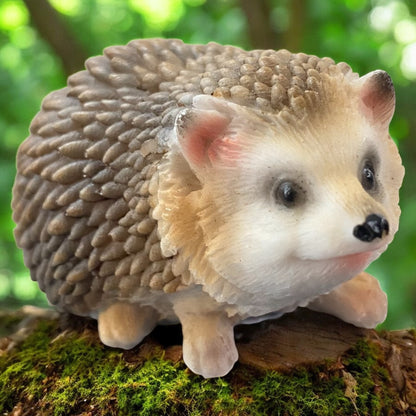 Stehende Igel-Figur mit lebensechter Gestaltung, niedliche Herbstdeko zwischen Blättern und Moos.