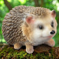 Stehende Igel-Figur mit lebensechter Gestaltung, niedliche Herbstdeko zwischen Blättern und Moos.