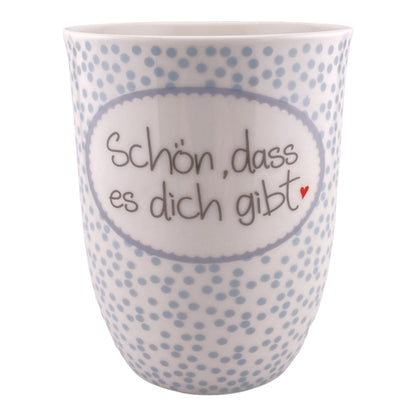 Eine blau weiß gepunktete Kaffeetasse mit Henkel und Schriftzug Schön, dass es dich gibt vor weißem Hintergrund