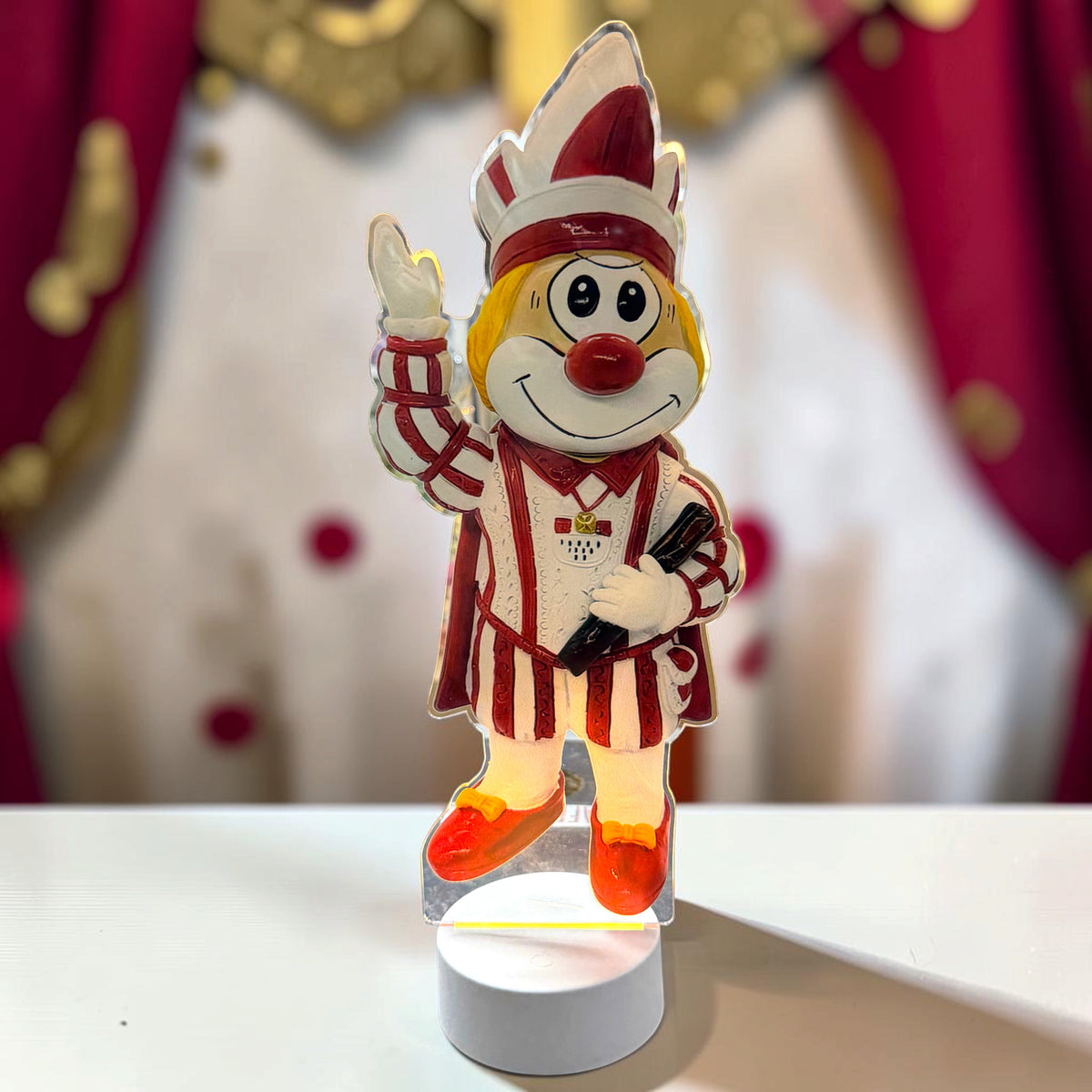 Schmitzens Karneval Deko Lampe Bauer in Schwarz und Weiß mit grünem Kopfschmuck vor rot-weißem Karnevalshintergrund.