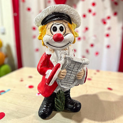 Karneval Deko Clown Die Schmitzens Lyraspieler mit silberner Lyra vor rot-weißer Karnevalsdekoration