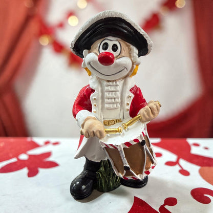 Karneval Deko Clown Die Schmitzens Trommler mit Trommel vor rot-weißer Karnevalsdekoration.