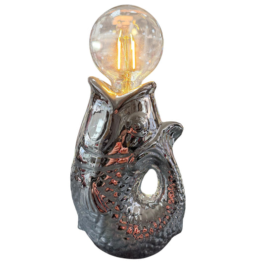 Moderne Tischlampe in Fischform aus glänzender silberfarbener Keramik mit sichtbarer LED-Glühbirne im Vintage-Stil, freigestellt vor weißem Hintergrund.