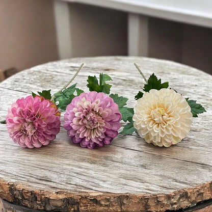 Drei künstliche Dahlienblüten in Rosa, Lila und Creme mit grünem Blattwerk und Stiel im Ambiente