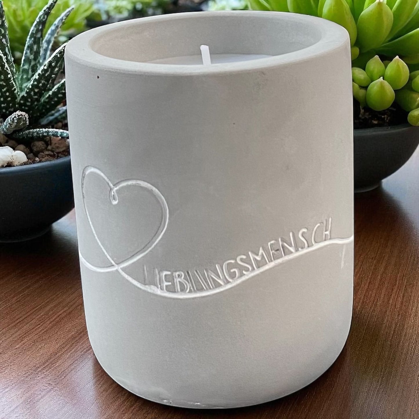 Eine Mea Living Kerze mit Spruch "Lieblingsmensch" in Betonoptik, 8 cm hoch, im Ambiente