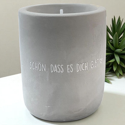 Eine Mea Living Kerze mit Spruch "Schön, dass es dich gibt" in Betonoptik, 8 cm hoch, im Ambiente