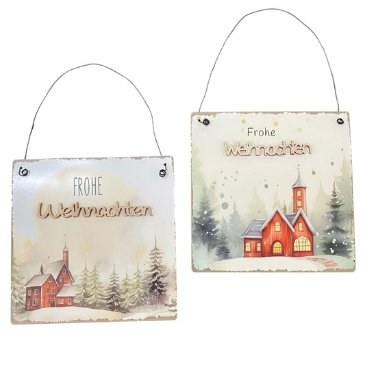 Zwei Metall-Dekoschilder mit der Aufschrift „Frohe Weihnachten“ und winterlichem Motiv einer roten Kirche im Schnee.