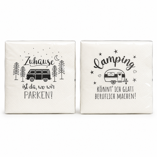 Zwei cremeweiße Papierservietten mit schwarzen Campingmotiven, Wohnmobil, Wohnwagen und Sprüchen vor weißem Hintergrund.