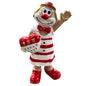 Clown-Figur mit roter Nase und rot-weiß gestreiftem Kleid, eine Hand erhoben und ein herzförmiges Objekt haltend, vor weißem Hintergrund.