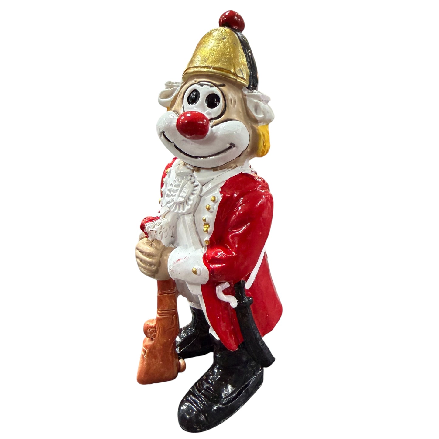 Clown-Figur mit roter Nase in roter Uniform und goldfarbenem Helm, hält ein Gewehr vor dem Körper, vor weißem Hintergrund.