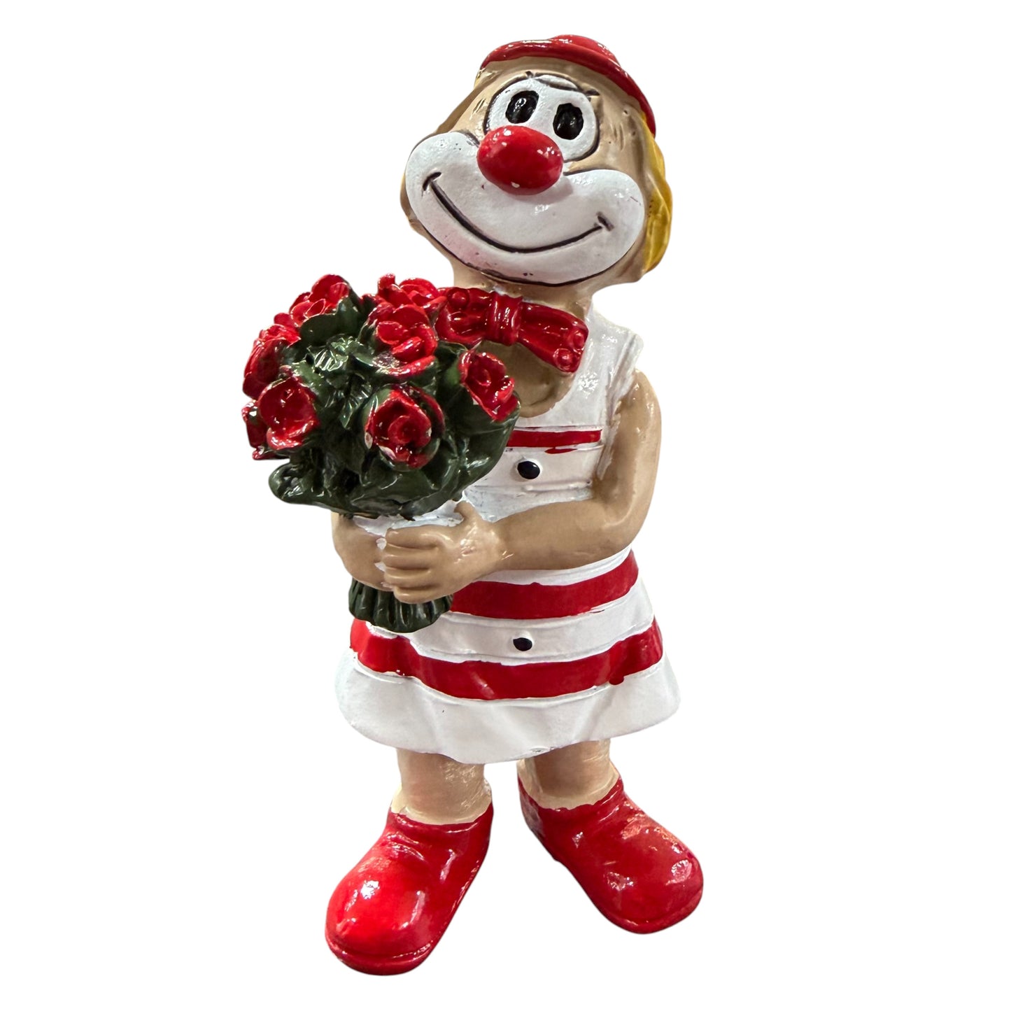 Clown-Figur mit roter Nase in rot-weißem Outfit, hält einen Blumenstrauß mit roten Rosen vor dem Körper, vor weißem Hintergrund.