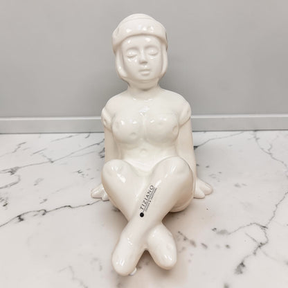 Cremeweiße Tiziano Keramik Dekofigur Badenixe Marie sitzend, 21 cm hoch, auf einer hellen Oberfläche vor grauem Hintergrund.