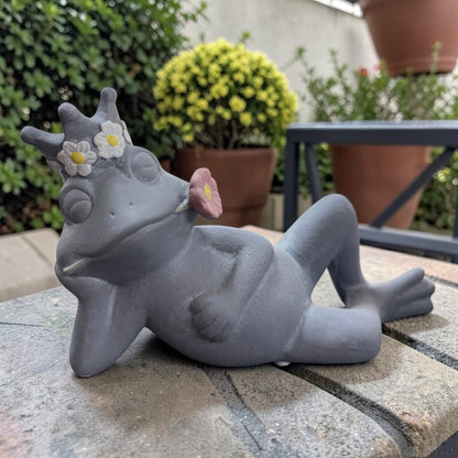 Liegender Deko-Frosch in Grau mit Blumenkrone und rosa Blüte im Mund aus Resin  im Ambiente