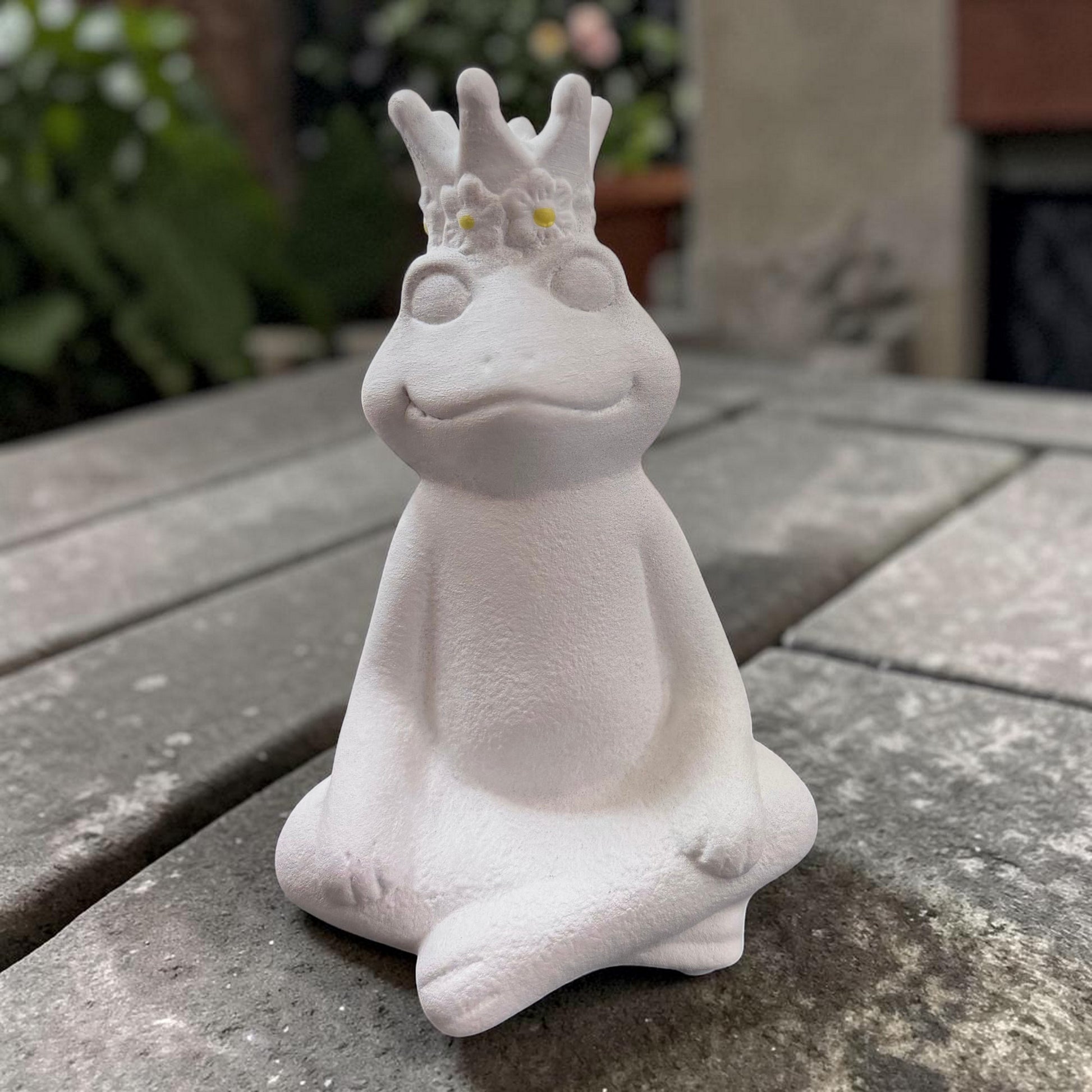 Weißer Deko-Frosch mit Krone und floralen Details als märchenhafte Garten- und Wohnraumdekoration.
