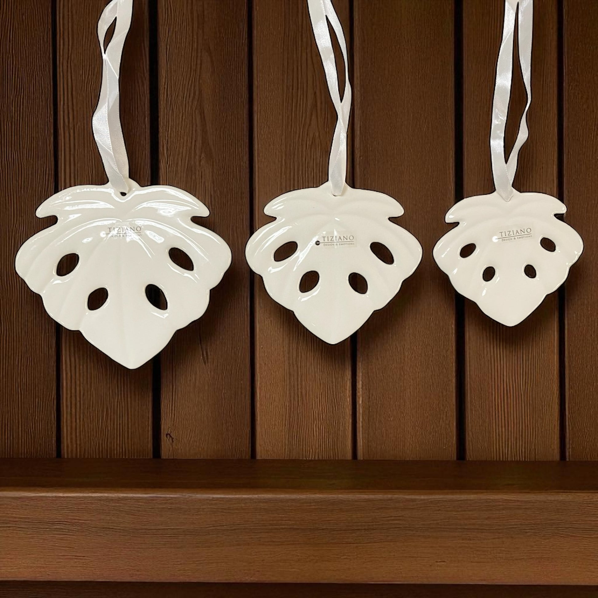 Drei creme-weiße Keramik Hänger in Blattform der Serie Tiziano Litus mit Satinband in den Größen 10 cm, 12 cm und 14 cm im Ambiente