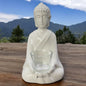 Eine creme-weiße Deko Buddha Figur von Tiziano aus creme-weißer Keramik mit Glaseinsatz als Teelichthalter im Ambiente