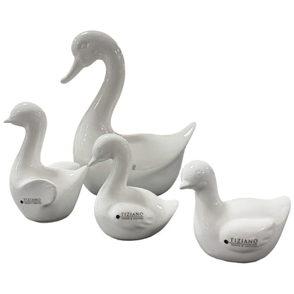 Weiße Keramikfiguren in Form einer Gans mit mehreren Küken, freigestellt auf weißem Hintergrund.