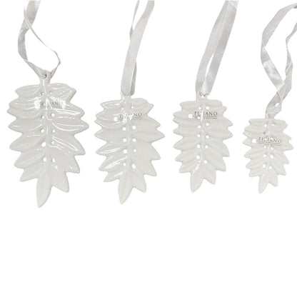 Unterschiedlich große Blatt-Anhänger aus Keramik in glänzendem Weiß, jeweils mit Tiziano Logo und Satinband zum Aufhängen