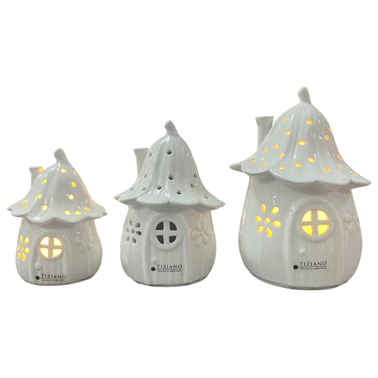 Weiße Keramik-Dekohäuser in drei Größen mit integrierter LED-Beleuchtung, runde Fenster und durchbrochene Muster, freigestellt auf weißem Hintergrund