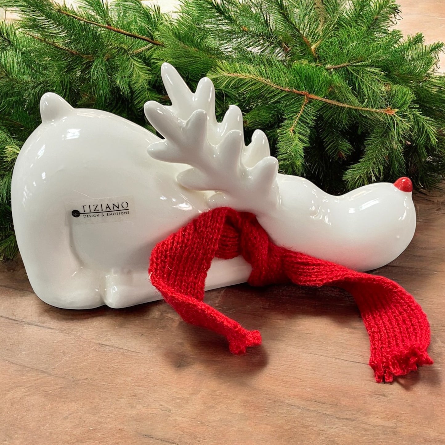 Ein creme-weißes Keramik Rentier mit rotem Schal mit Kopf nach unten von Tiziano im Ambiente