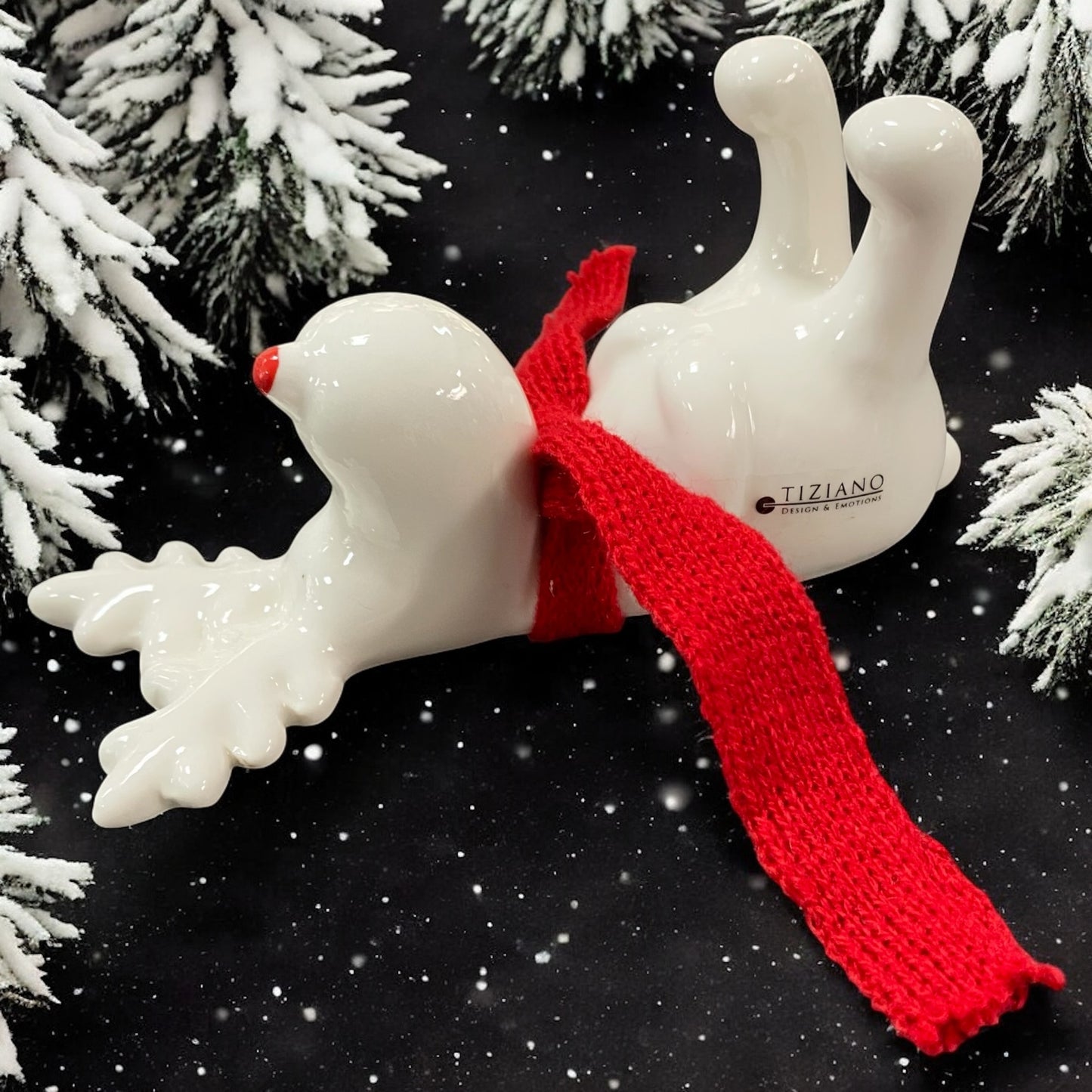 Ein creme-weißes Keramik Rentier mit rotem Schal liegend von Tiziano im Ambiente