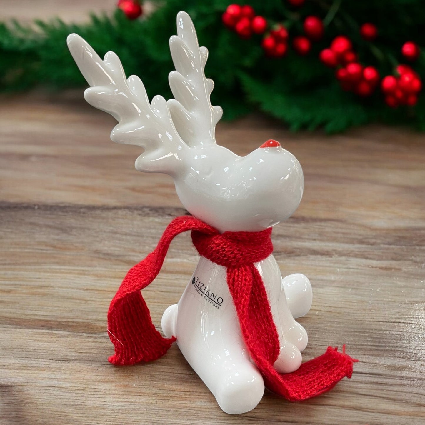 Ein creme-weißes Keramik Rentier mit rotem Schal sitzend von Tiziano im Ambiente