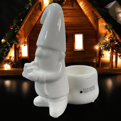 Ein creme-weißer Keramik Weihnachtsmann stehend mit Geschenk in der Hand als Teelichthalter im Ambiente