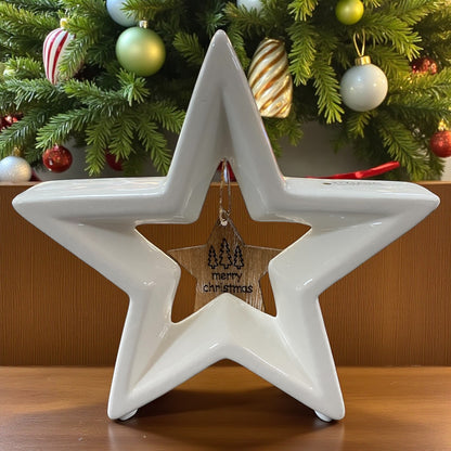 Ein großer stehender creme-weißer Tiziano Keramik Stern Cascata mit hängendem Holzstern Merry Christmas im Ambiente 