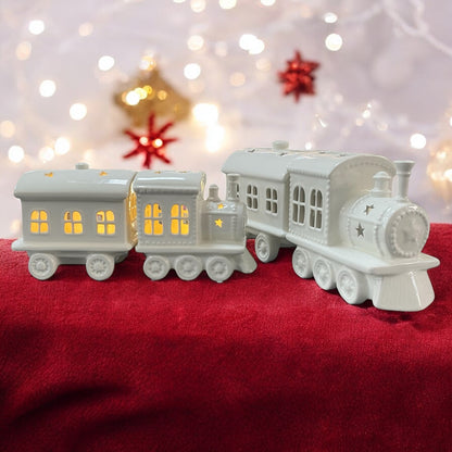 Zwei Keramik Weihnachtszüge von Tiziano in Creme Weiß mit Stern-Ausschnitten und integrierter LED Beleuchtung im Ambiente