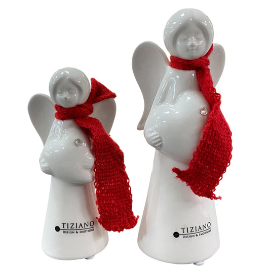 Zwei Keramik Schutzengel mit rotem Schal als Dekoration vor weißem Hintergrund platziert. Die Engel tragen ein Herz in ihren Händen und haben ausgebreitete Engelsflügel. 