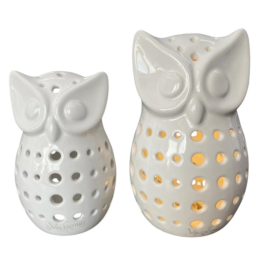Zwei creme-weiße Keramik Eulen Figuren mit runden Aussparungen, durch welche warmes LED Licht strahlt