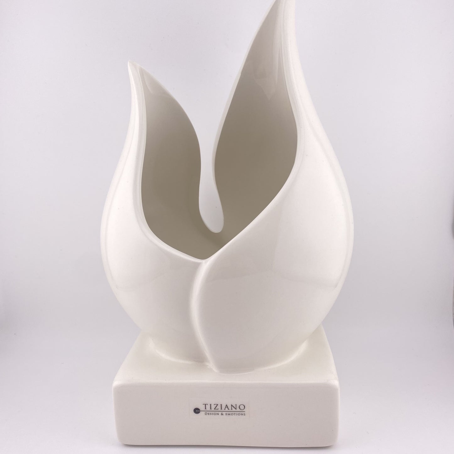 Eine große Pflanzenschale aus creme-weißer Keramik vor weißem Hintergrund platziert. Die Vase besteht aus einem Sockel, auf dem zwei Blätter eine tulpenartige Vase und damit eine Öffnung formen. Die Keramikvase ist 26cm groß. 