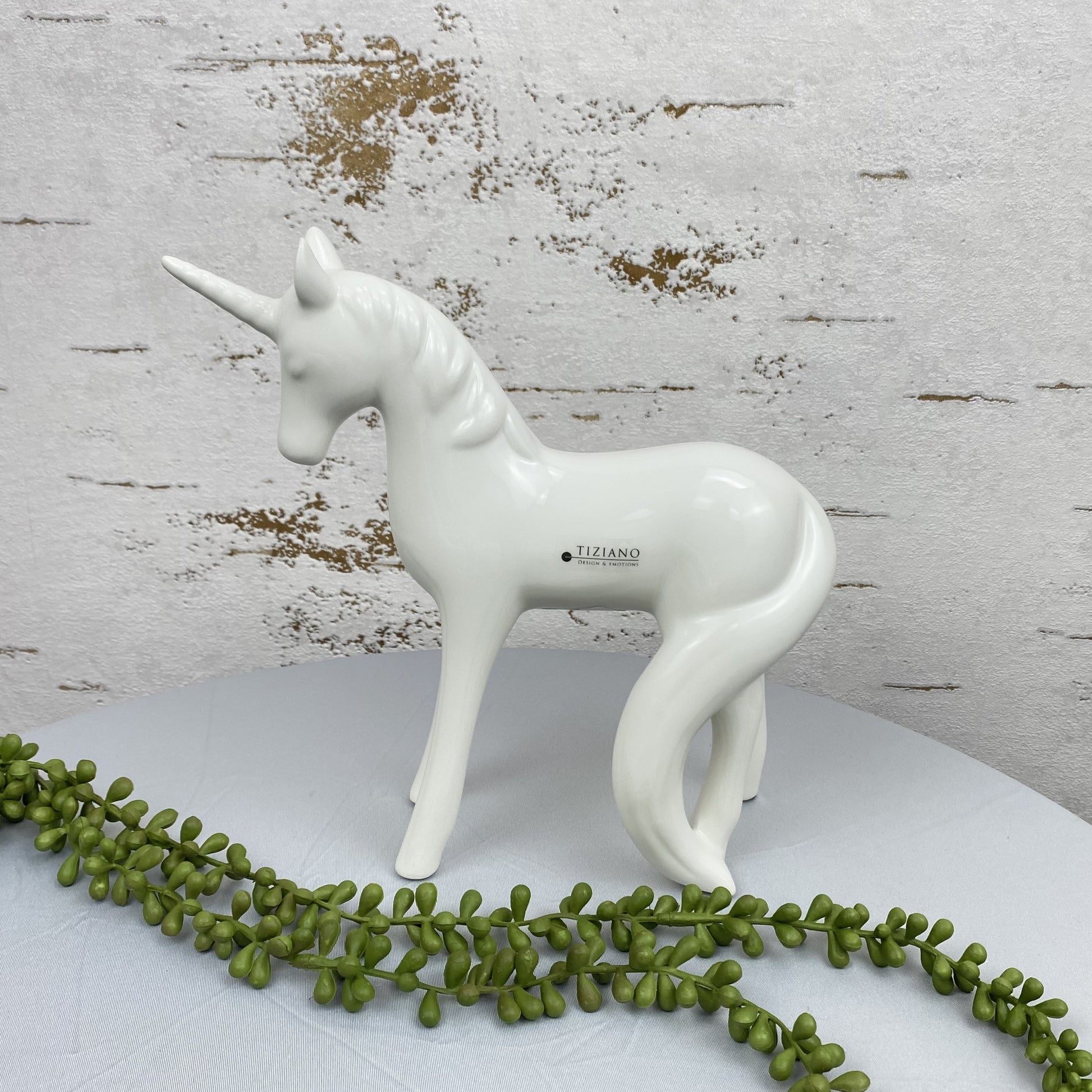 Großes Keramik Einhorn als Dekofigur im Ambiente. Das Deko Einhorn hat einen Schweif, ein Horn und die Ohren gespitzt.