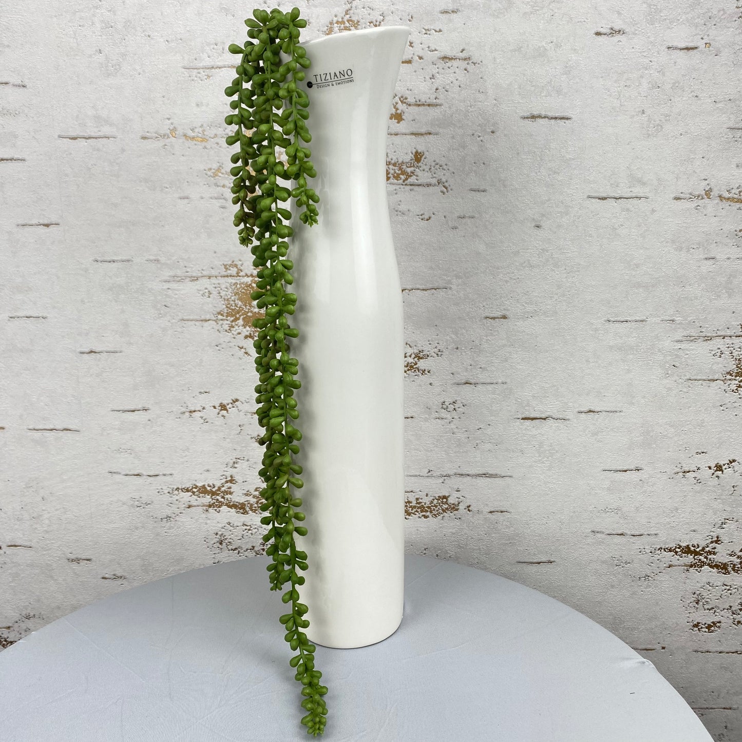 Eine 50 cm hohe, creme-weiße Keramik Deko Vase ist im Ambiente platziert. Die Vase ist schmal und sehr hoch.