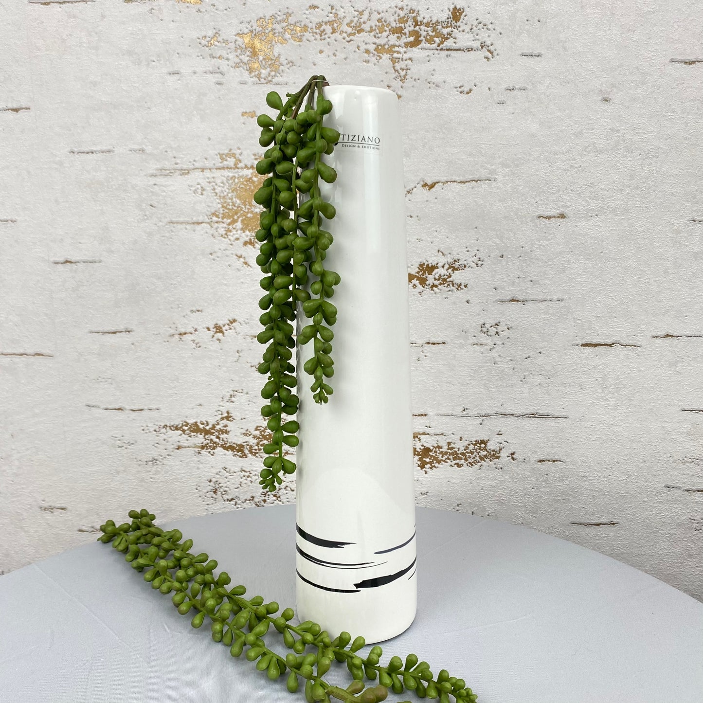 Eine 34 cm hohe, creme-weiße Keramik Deko Vase ist im Ambiente  platziert. Die Vase ist schmal und sehr hoch.