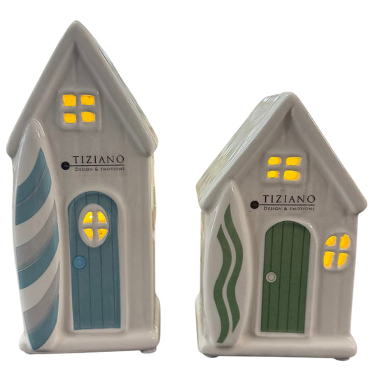 Zwei weiße Keramikhäuser mit integrierter LED-Beleuchtung und grünen sowie blauen Tür- und Seitendetails stehen vor weißem Hintergrund.