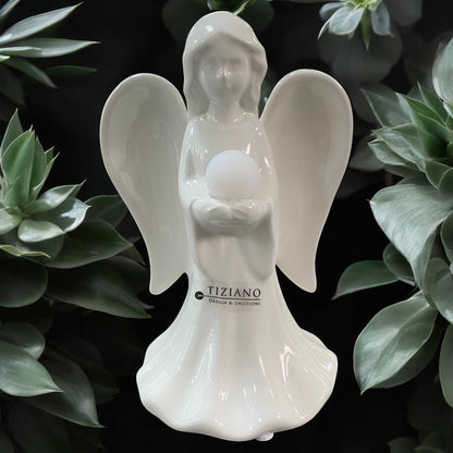 Eine creme-weiße Keramik Engel Figuren Delia mit Kugel in den Händen im Ambiente