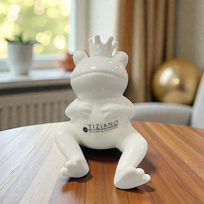 Weiße Keramik-Froschfigur Vico mit Krone – sitzend, Hände vor dem Bauch, dekorative Aufnahme im Innenraum