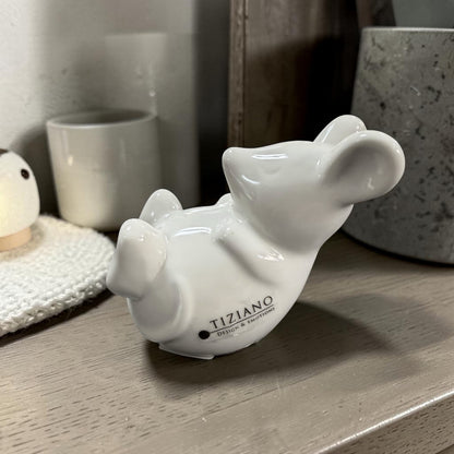 Weiße Keramikmaus mit minimalistischer Form und glänzender Glasur in gemütlicher Wohnatmosphäre.