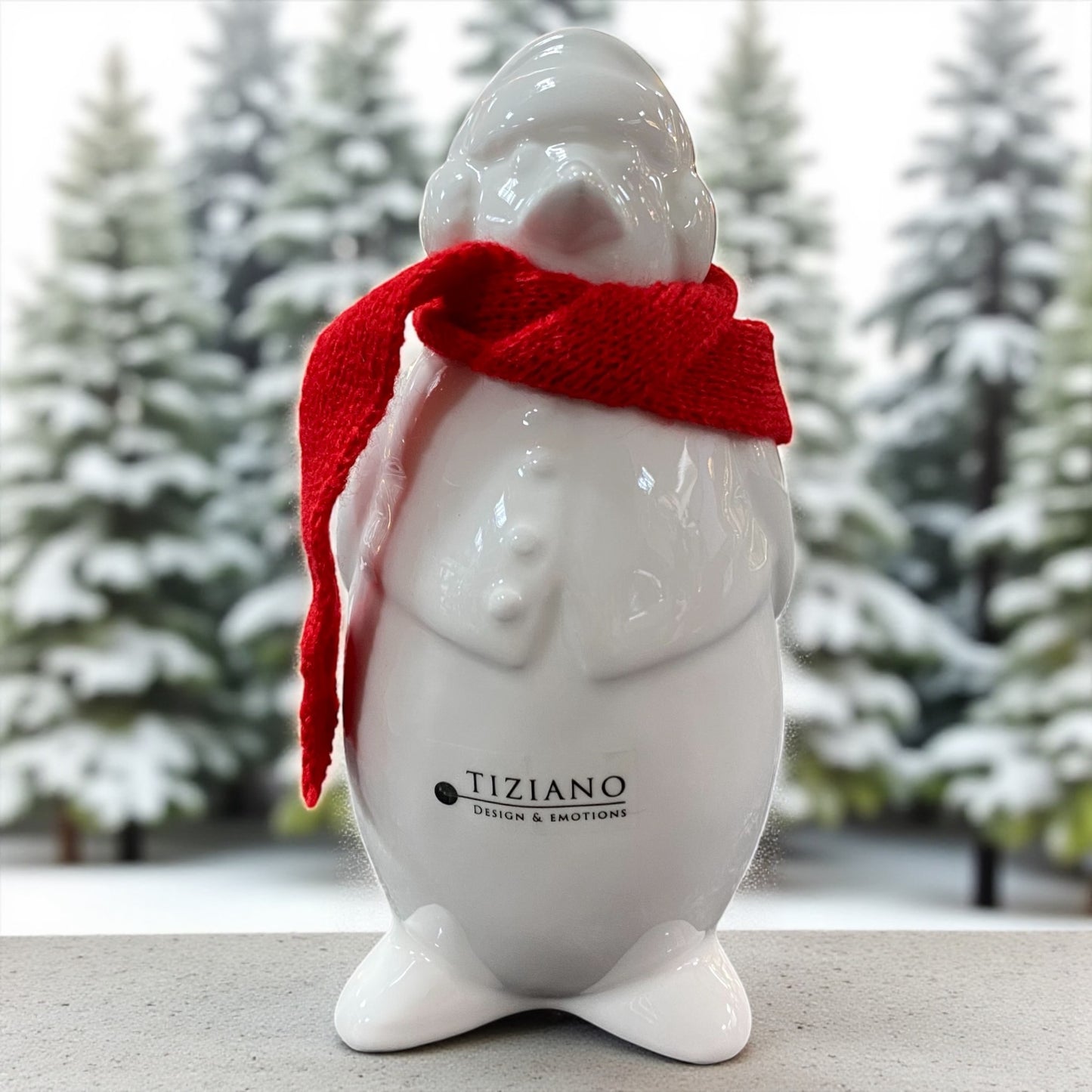 Ein creme-weißer Keramik Pinguin mit roten Schals und Mütze nach hinten von Tiziano im Ambiente