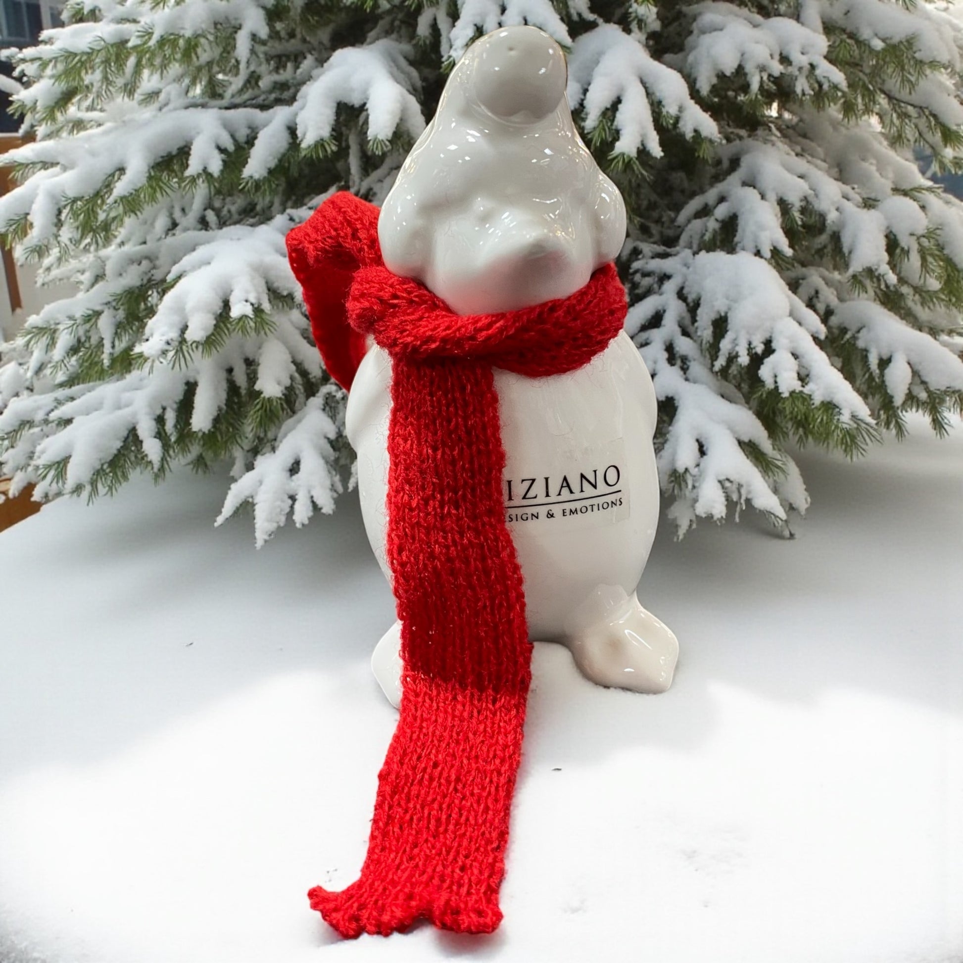 Ein creme-weißer Keramik Pinguin mit roten Schals und Mütze nach vorne von Tiziano im Ambiente