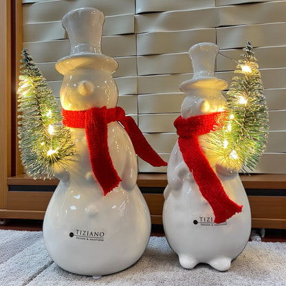 Zwei creme-weiße Keramik Schneemänner mit rotem Schal und beleuchtetem Tannenbaum, Serie Sören von Tiziano im Ambiente
