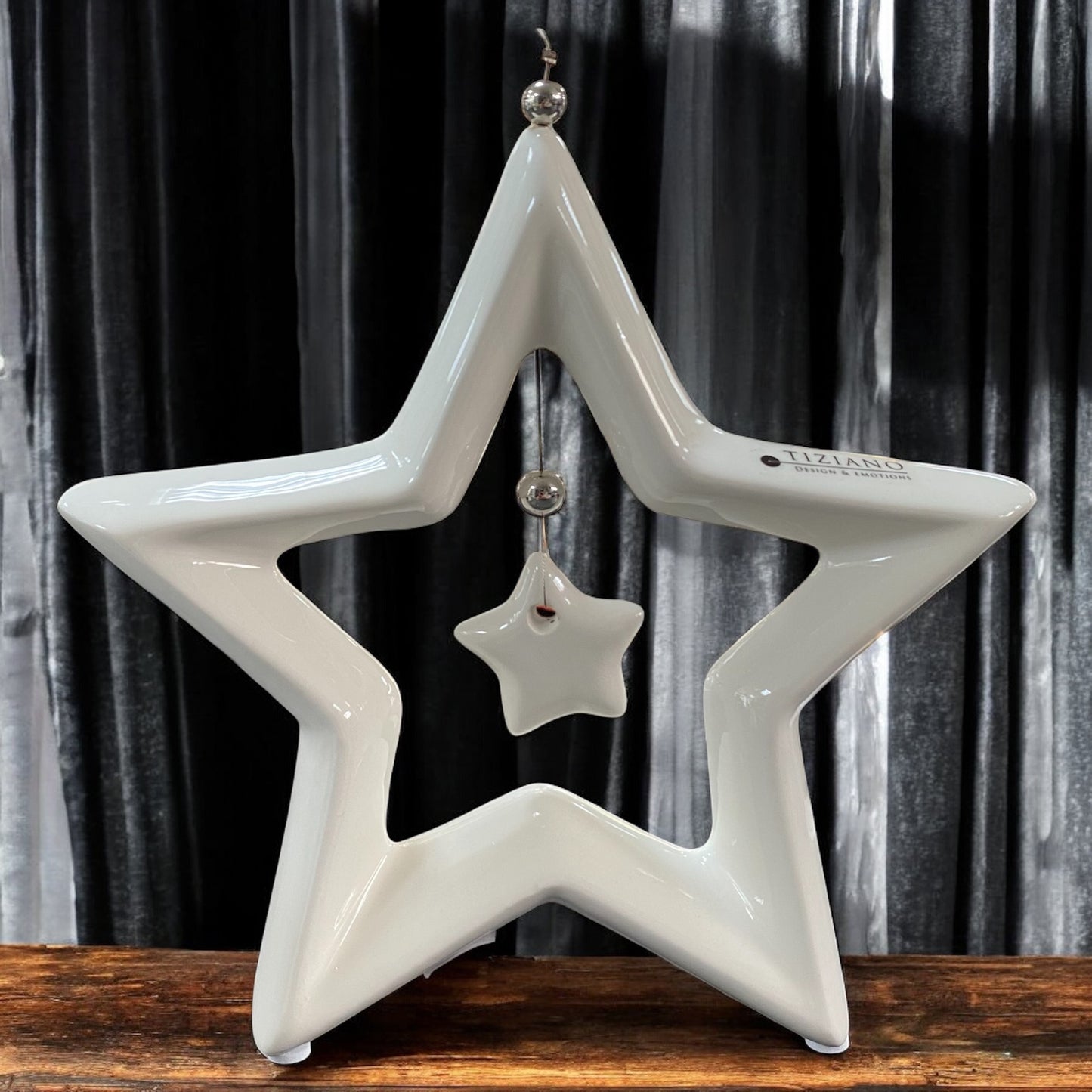 Ein creme-weißer Keramik Stern Saphira mit kleinem hängenden Stern in der Mitte im Ambiente